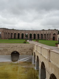 View of arch bridge against cloudy sky