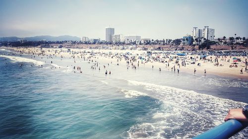 People enjoying at beach against clear sky