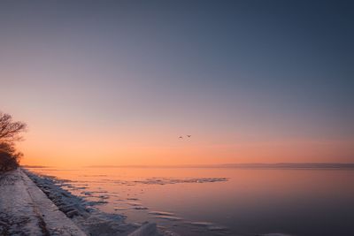 Scenic view of sea against clear sky during sunset
