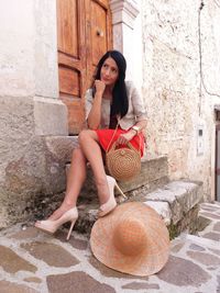 Portrait of smiling young woman sitting outdoors