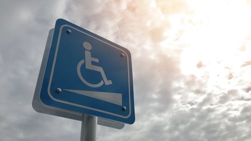 Low angle view of road sign against sky