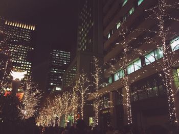 Low angle view of illuminated lights in city at night