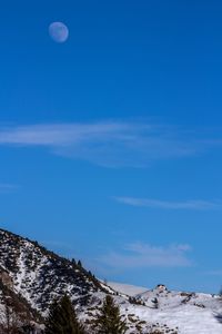 Scenic view of snowcapped mountains against blue sky