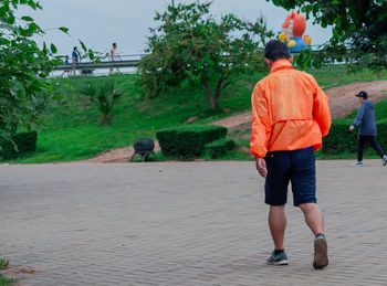 Rear view of people walking on footpath