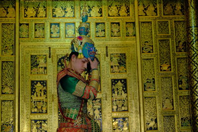 Low angle view of woman standing against wall