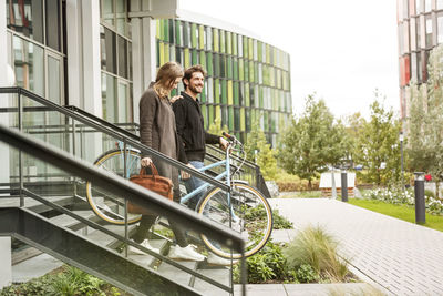 Smiling couple leaving house with bicycles