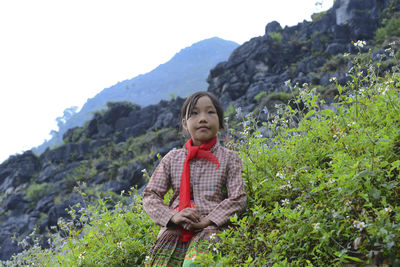 Portrait of senior woman on land against sky