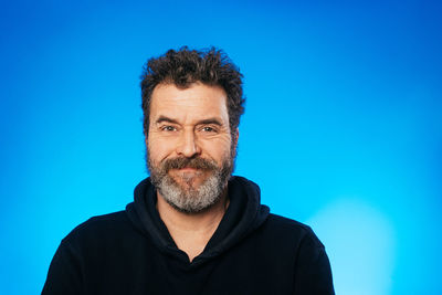 Portrait of young man against blue background