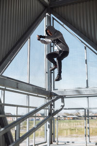 Full length of man jumping on railing