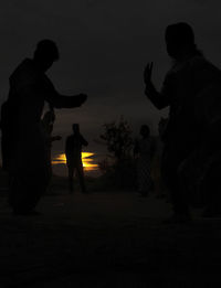 Silhouette people standing against sky during sunset