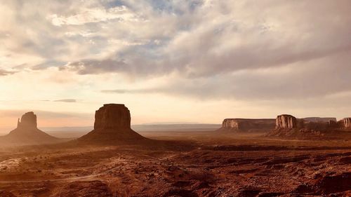 Rock formations on landscape against sky during sunset