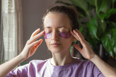 Young woman with purple patches under eyes. skin care and daily morning routine concept.