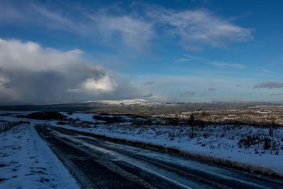 Snow covered road against sky