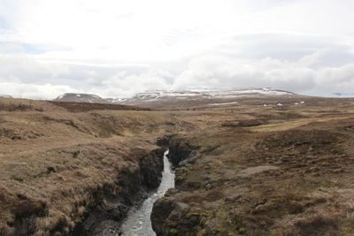 Scenic view of waterfall against sky