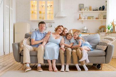 Big happy family sitting on sofa in living room, happy and joyful smile. family