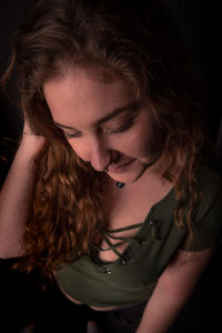 Young woman standing over black background