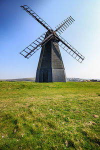 Traditional windmill on field against clear sky