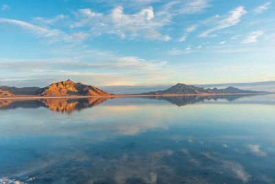 Scenic view of lake by snowcapped mountains against sky