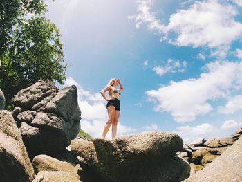 Man standing on rock against sky