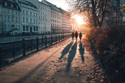 People walking by canal in city