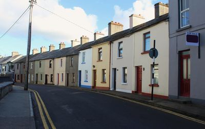 Empty road by buildings against sky