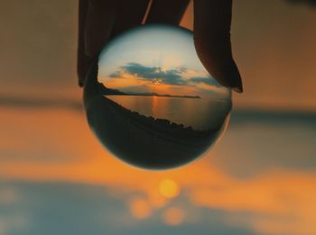 Close-up of crystal ball against sky during sunset