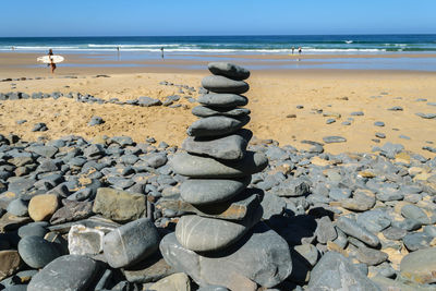 Stack of pebbles on beach against sky