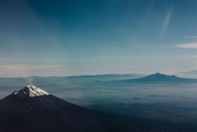 Scenic view of snowcapped mountains against cloudy sky