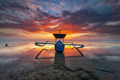 Sunglasses on beach against sky during sunset