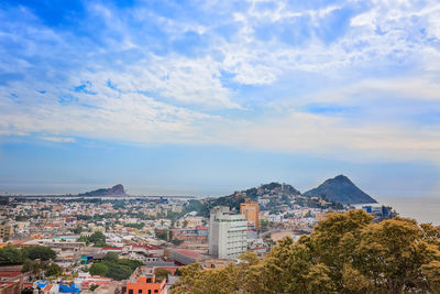 Buildings in city against cloudy sky