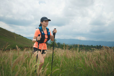 Portrait of young woman standing on field