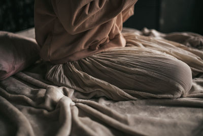 Close-up of hands working on bed