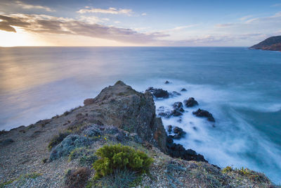 Scenic view of sea and mountains against sky during sunset