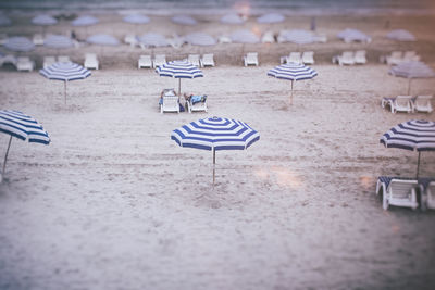 High angle view of blue striped parasols on sand at beach