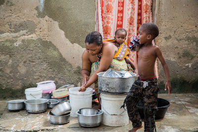 Woman with children washing utensils at home