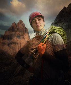 Man holding rock against sky