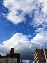 Low angle view of buildings against cloudy sky