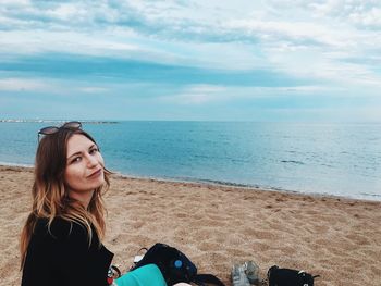 Portrait of woman on beach against sky