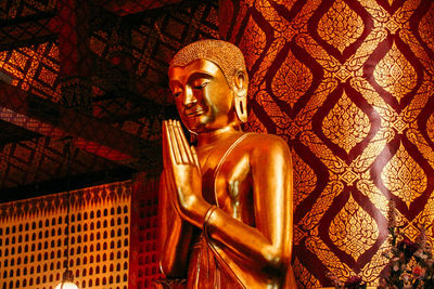 Low angle view of buddha statue against building