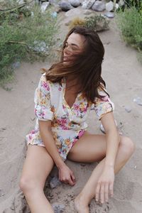 Young woman sitting on tree