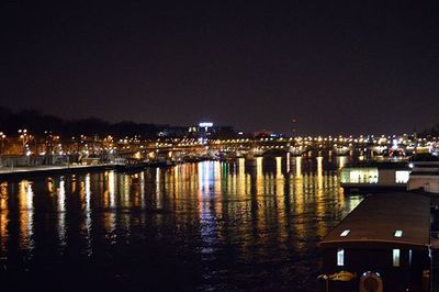 Illuminated bridge over river at night