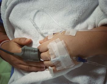 Midsection of woman wearing iv drip in hospital