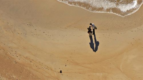 High angle view of friends standing at beach