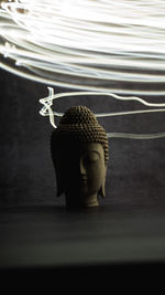 Close-up of buddha statue on table