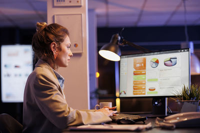 Portrait of young woman using mobile phone in office