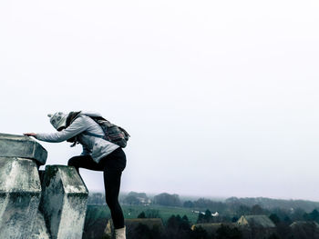 Young woman standing against clear sky