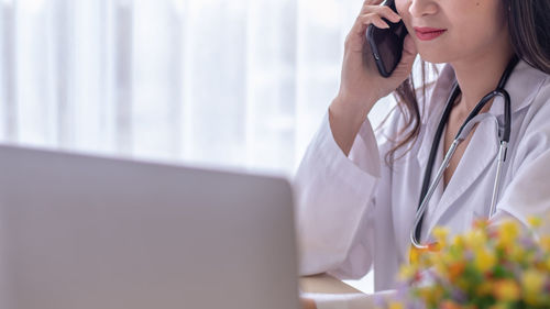 Midsection of woman using mobile phone