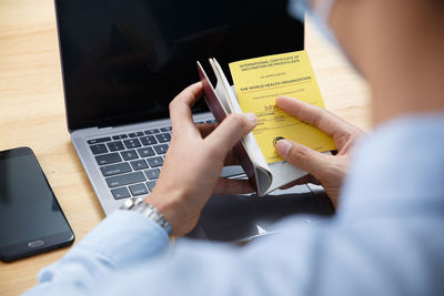 Midsection of man using mobile phone on table