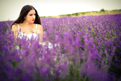 Beautiful young woman with yellow flowers on field