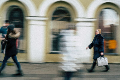 Side view of people walking in city